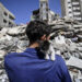 Ahmed Mosabeh, a 28-year-old Palestinian man with special needs, holds one of several rescue kitten he cares for, next to a destroyed building, after evacuating his home earlier to a safer area due to Israeli air raids in Gaza City, on May 18, 2021. - Israel launched its air campaign on the Gaza Strip controlled by the Palestinian Hamas group on May 10, after the enclave's rulers fired a barrage of rockets in response to unrest in Israeli-annexed east Jerusalem. (Photo by Mahmud Hams / AFP)